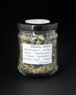 clear glass jar with black lid containing "heart balm" herbal tea blend by blueberryjams.