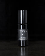 10ml black glass bottle of LVNEA's l'Alchimie natural roll on perfume on black background