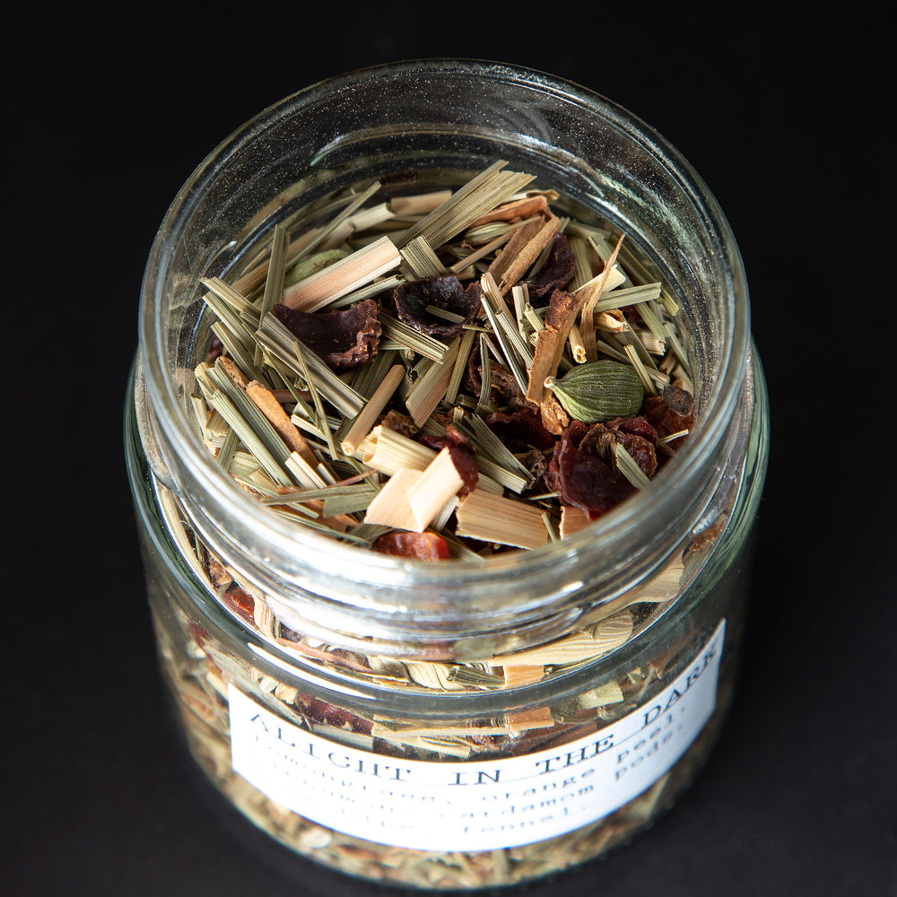 
                      
                        Open jar of blueberryams' "Alight in the Dark" herbal tea. Whole cardamom pods and other botanical ingredients are visible.
                      
                    