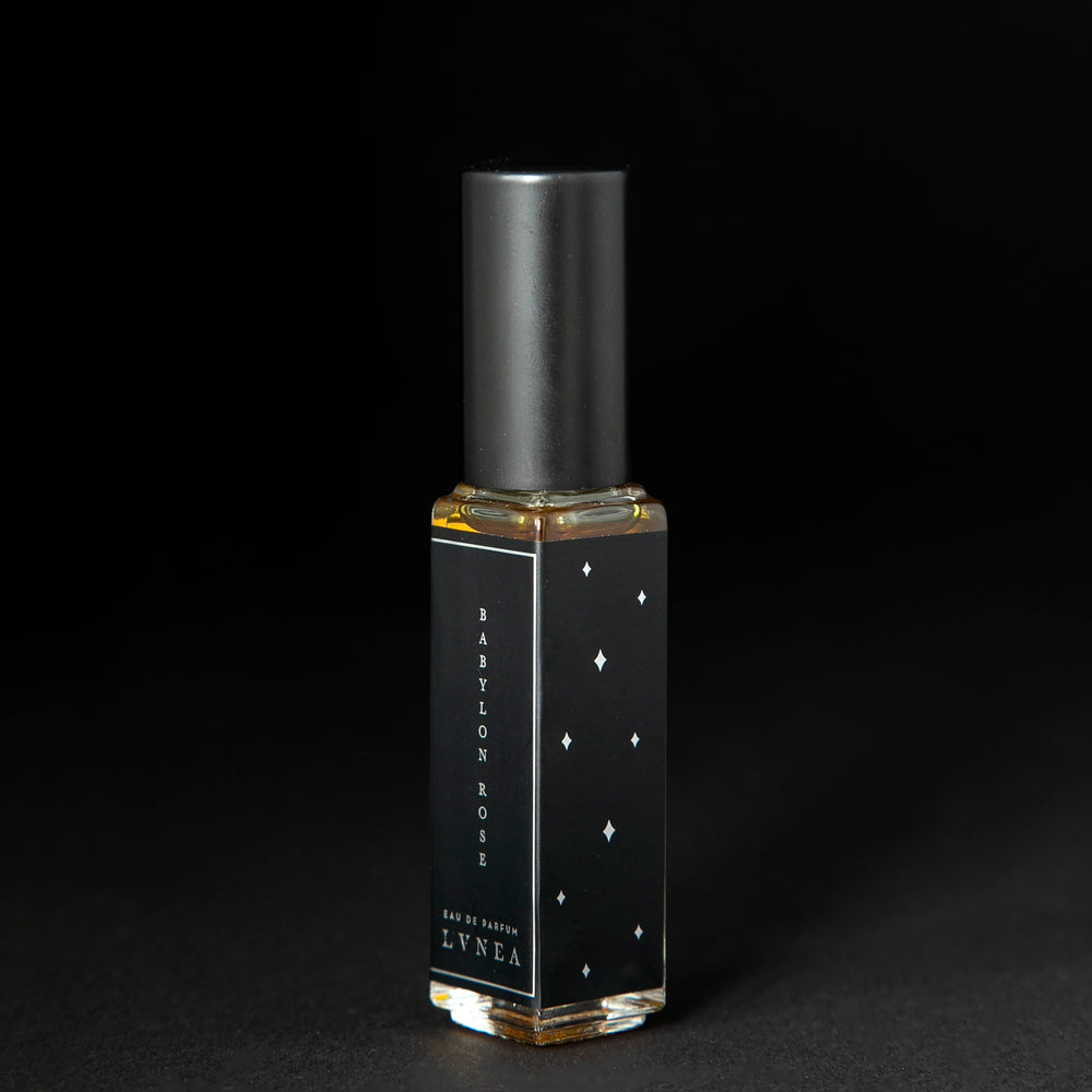 
                      
                        8ml clear glass bottle with black and silver label of LVNEA's limited edition Babylon Rose perfume on black background.
                      
                    