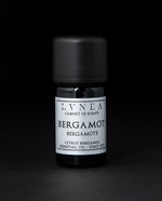5ml black glass bottle with silver label of LVNEA's bergamot essential oil on black background