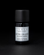 5ml black glass bottle of LVNEA's bitter orange essential oil on black background. The bottle has a silver label.