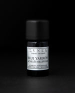 5ml black glass bottle of LVNEA's blue yarrow essential oil on black background. The label on the bottle is silver.