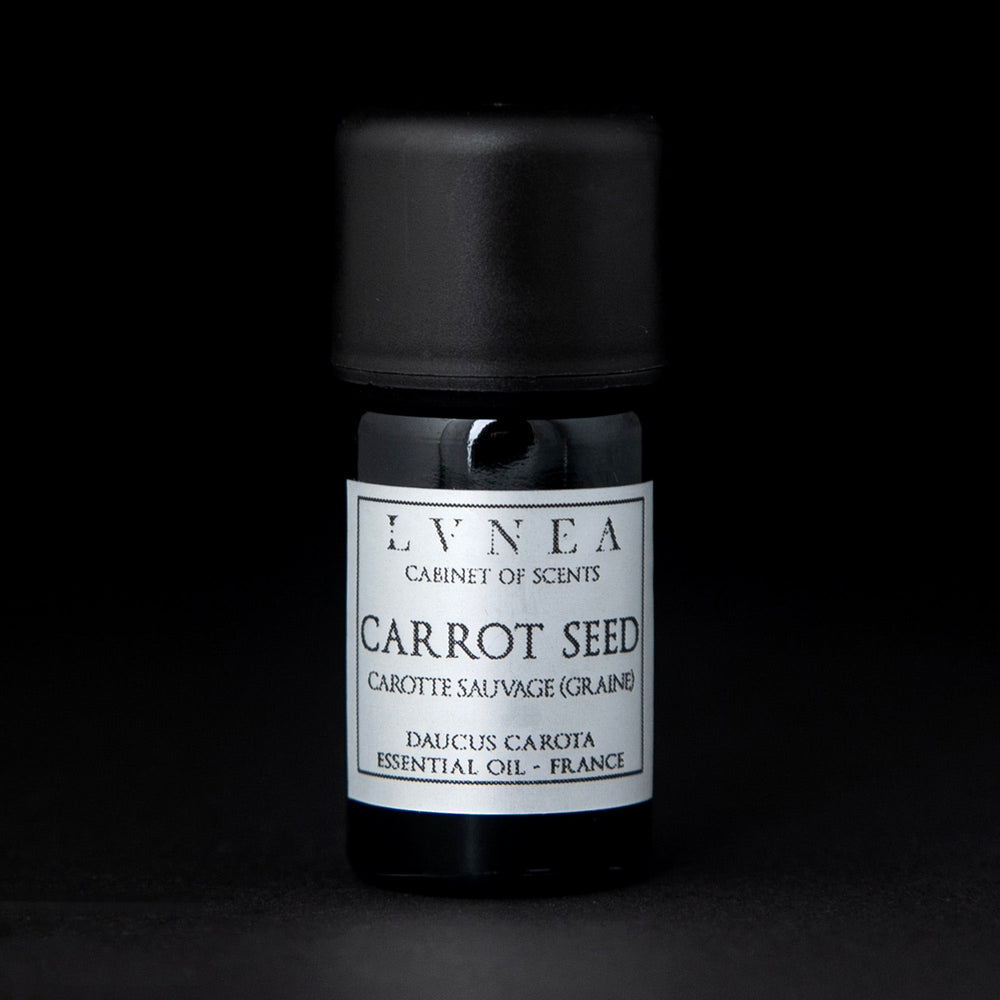 5ml black glass bottle with silver label of LVNEA's carrot seed essential oil on black background