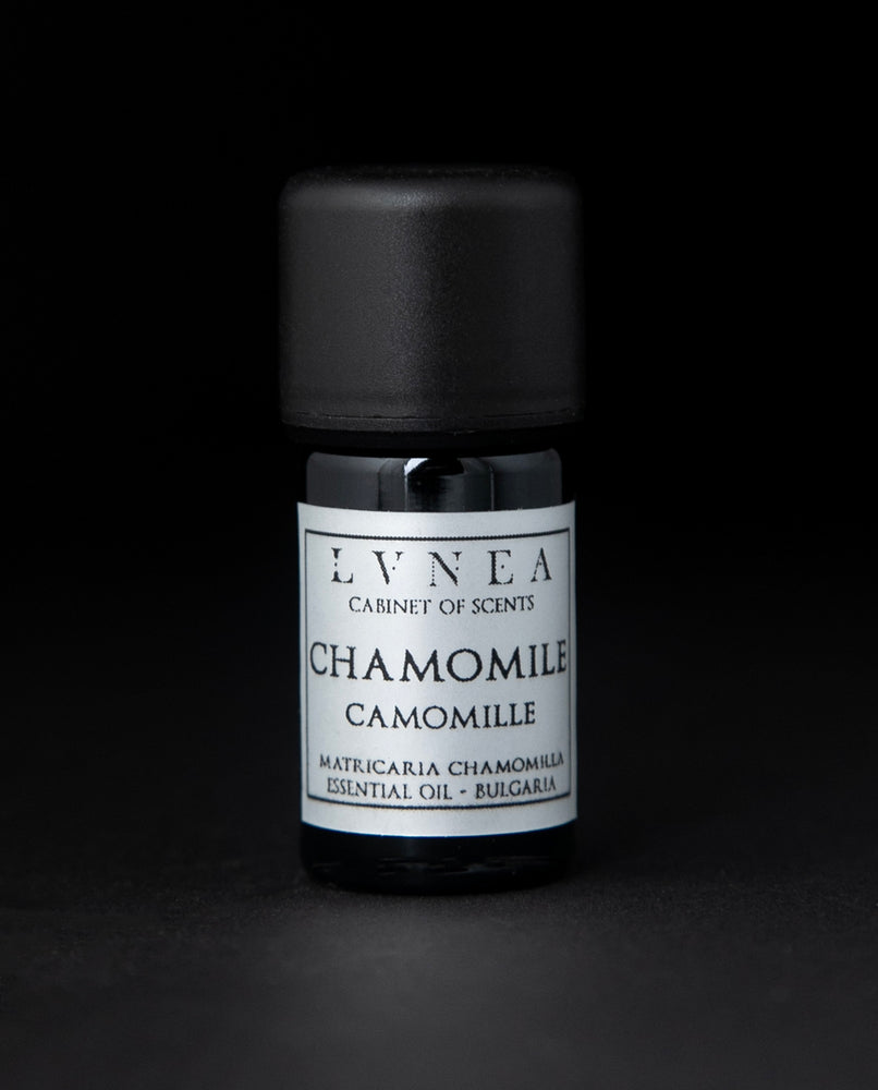 5ml black glass bottle with silver label of LVNEA's chamomile essential oil on black background