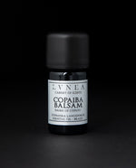 5ml black glass bottle with silver label of LVNEA's copaiba balsam essential oil on black background
