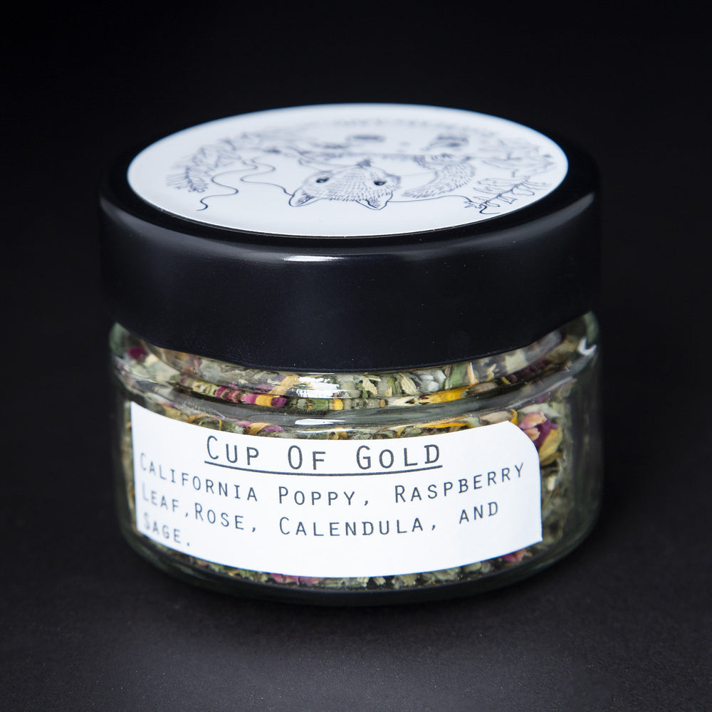 Clear glass jar with black lid containing blueberryjams' "Cup of Gold" rolling blend. English label is visible.