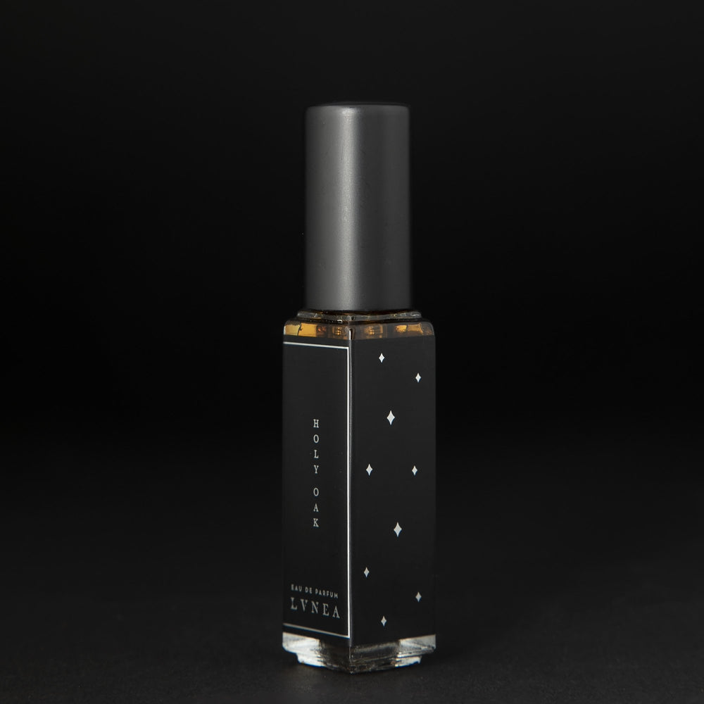 
                      
                        8ml clear glass bottle of LVNEA’s Holy Oak natural perfume on black background, bottle is rotated at a 3/4 angle exposing a star pattern on the label.
                      
                    