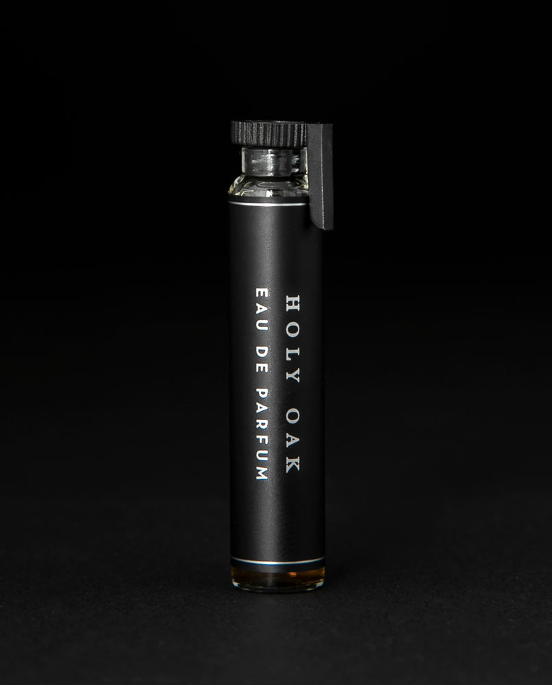 2ml glass sample vial of LVNEA's Holy Oak natural perfume on black background