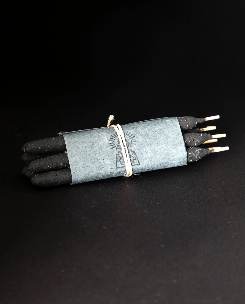 one bundle of Incausa's hand-rolled chacrona and jagube incense wrapped in white paper and twine, on a black background