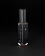 8ml clear bottle of LVNEA'S L'Incarnation natural perfume on black background, bottle is rotated at a 3/4 angle exposing a star pattern on the label.