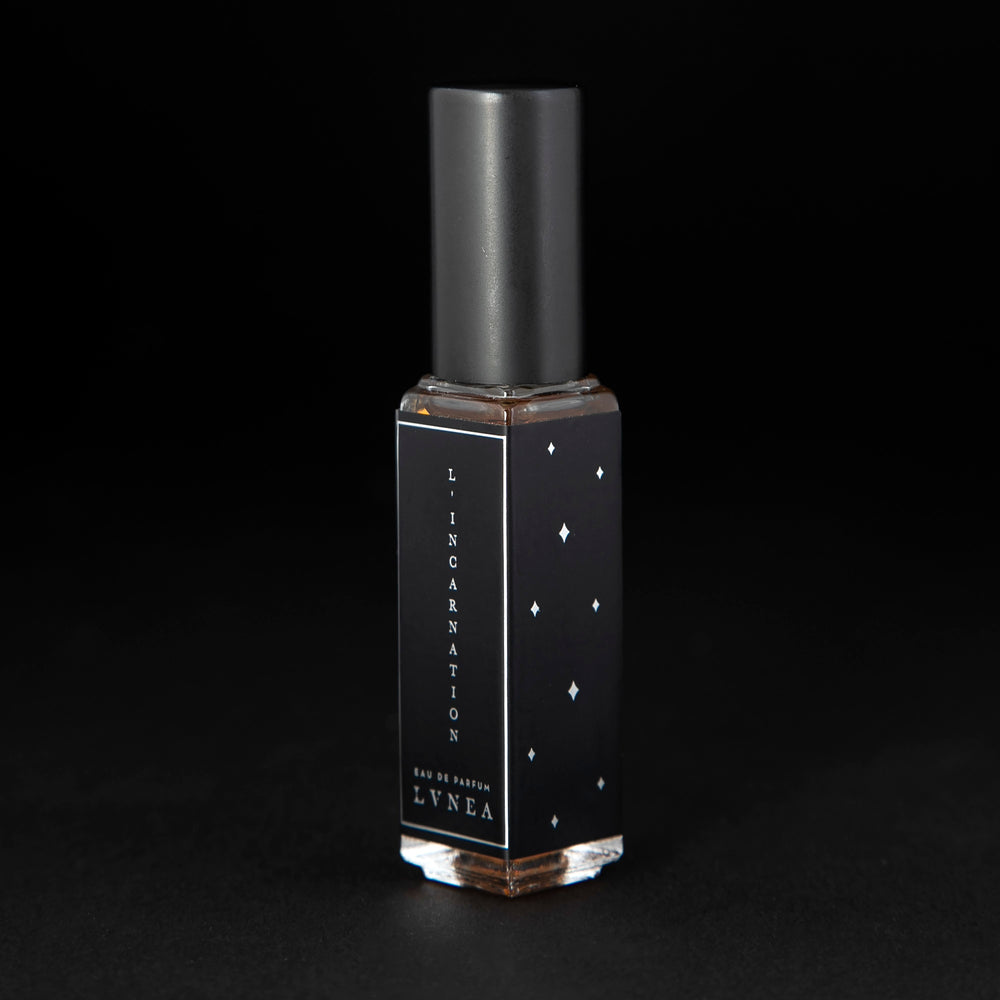 
                      
                        8ml clear bottle of LVNEA'S L'Incarnation natural perfume on black background, bottle is rotated at a 3/4 angle exposing a star pattern on the label.
                      
                    