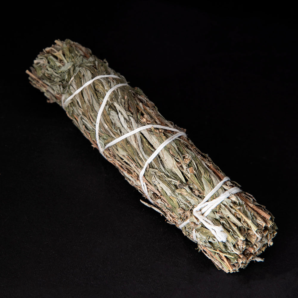 
                      
                        bundle of dried mugwort wrapped in white string on black background.
                      
                    