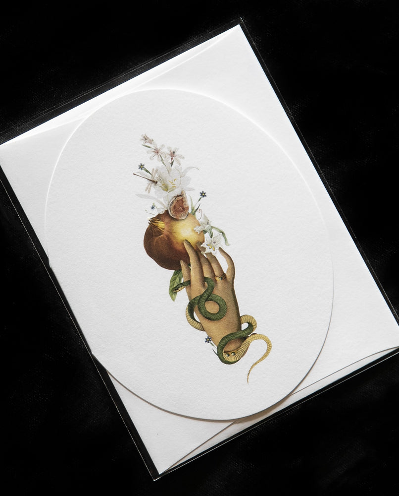 white oval greeting card with victorian-style illustration of a hand holding a pomegranate