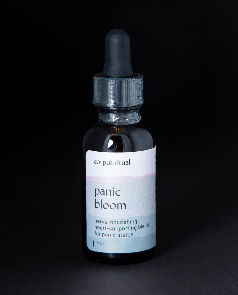 Black glass bottle with dropper top of Corpus Ritual's "Panic Bloom" herbal tincture.