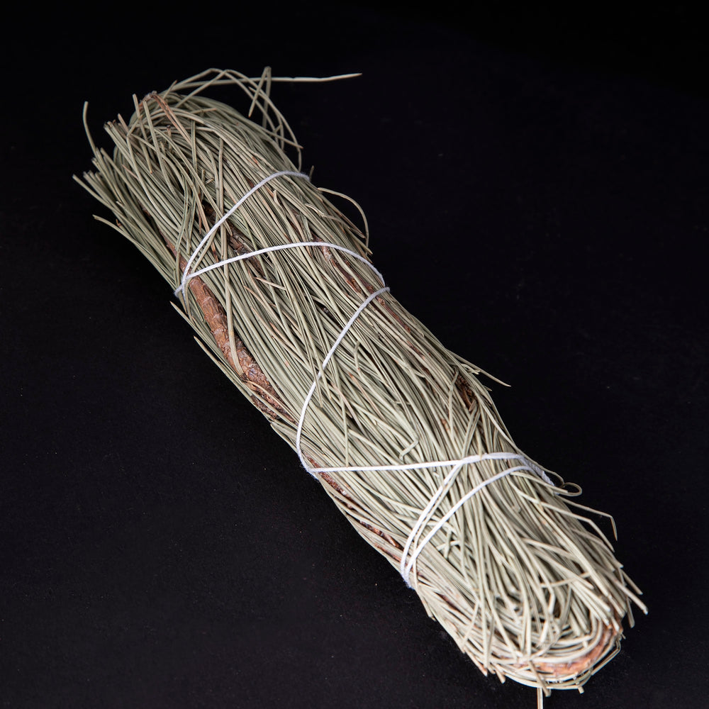 
                      
                        bundle of dried pinon pine wrapped in white string on black background.
                      
                    