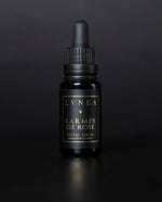 LVNEA's Larmes de Rose facial serum housed in a 20ml black glass bottle with dropper top on a black background.