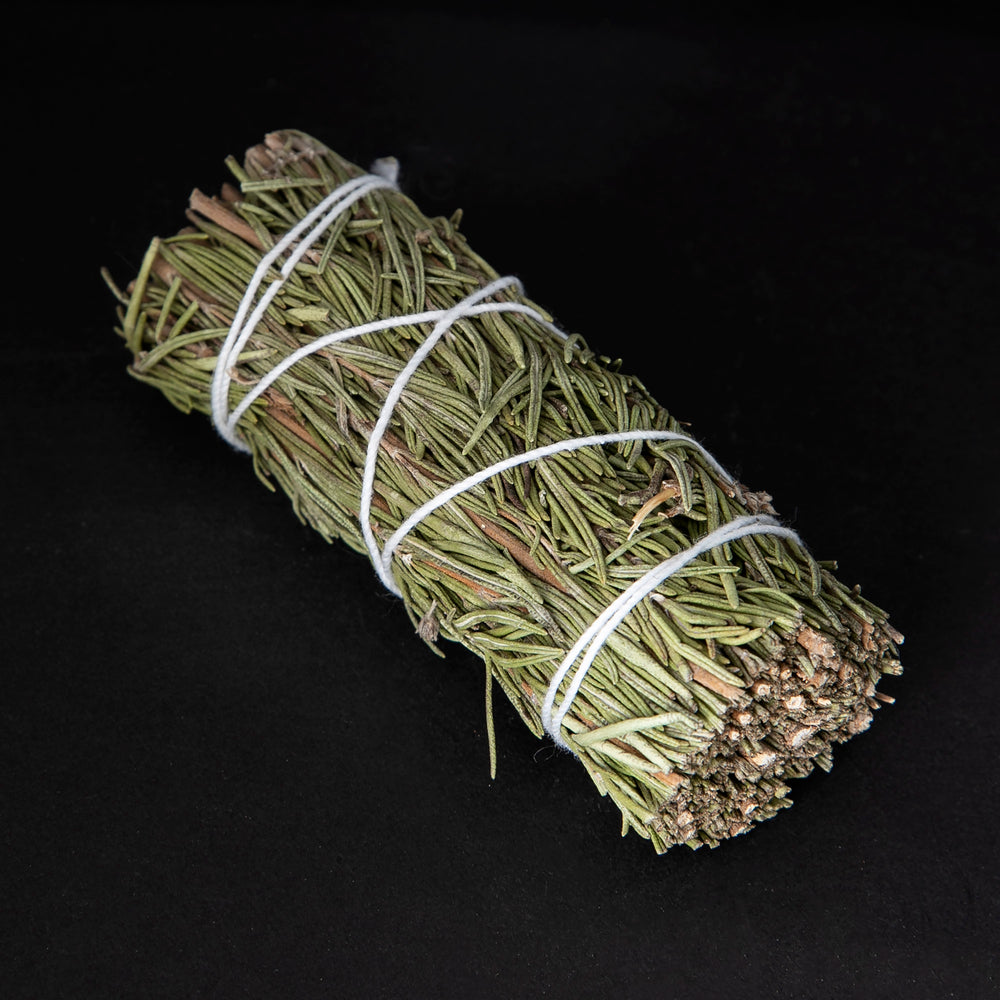 
                      
                        bundle of dried rosemary wrapped in white string on black background.
                      
                    