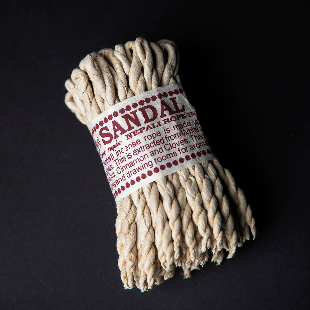 
                      
                        Bundle of sandalwood rope incense wrapped together with cream paper label.
                      
                    