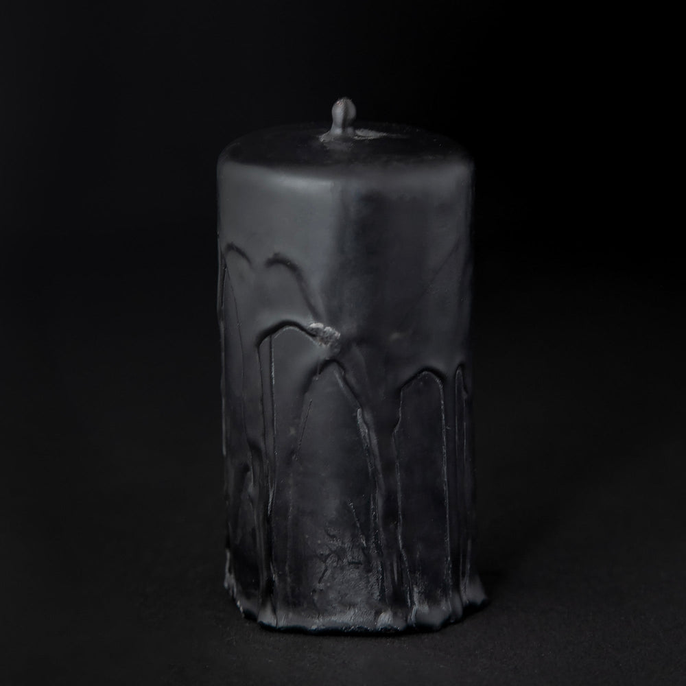 
                      
                        Black beeswax pillar candle by RITUAALIA with label removed, revealing the candle's rustic textured finish.
                      
                    