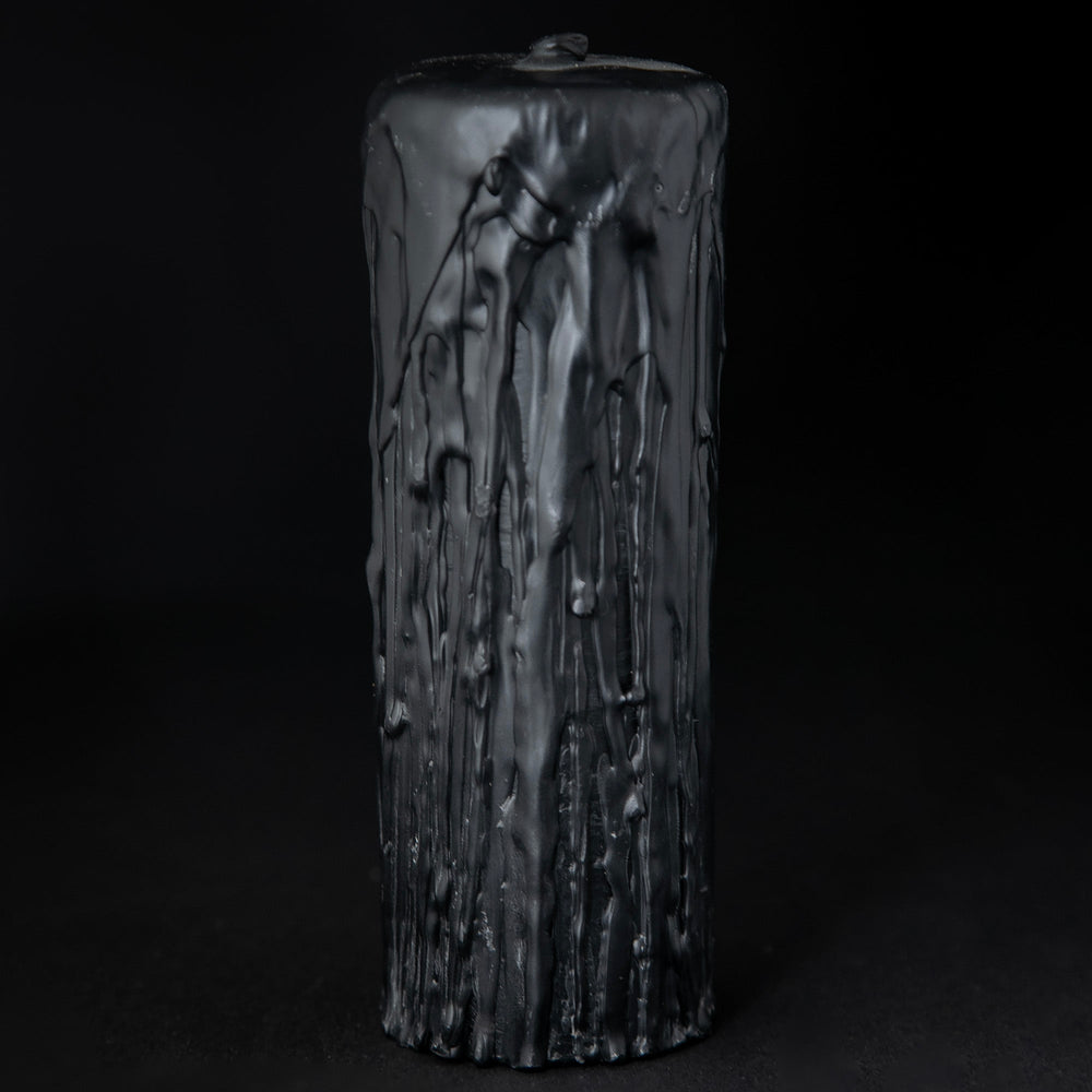 
                      
                        Black beeswax pillar candle by RITUAALIA with label removed, revealing the candle's rustic textured finish.
                      
                    