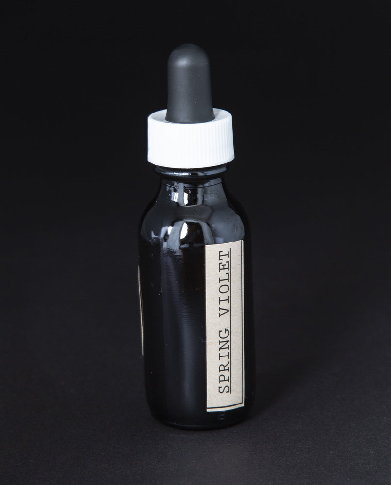 black glass bottle with dropper top of blueberryjams' spring violet herbal tincture.