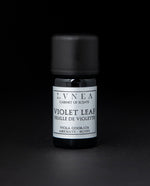 5ml black glass bottle of LVNEA's violet leaf absolute on black background. The label on the bottle is silver.